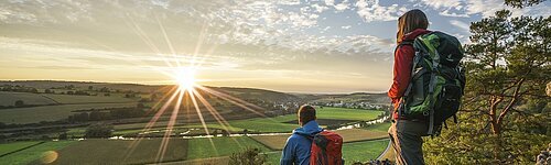 Wanderer auf dem Altmühltal-Panoramaweg genießen den Sonnenuntergang auf dem Burgsteinfelsen